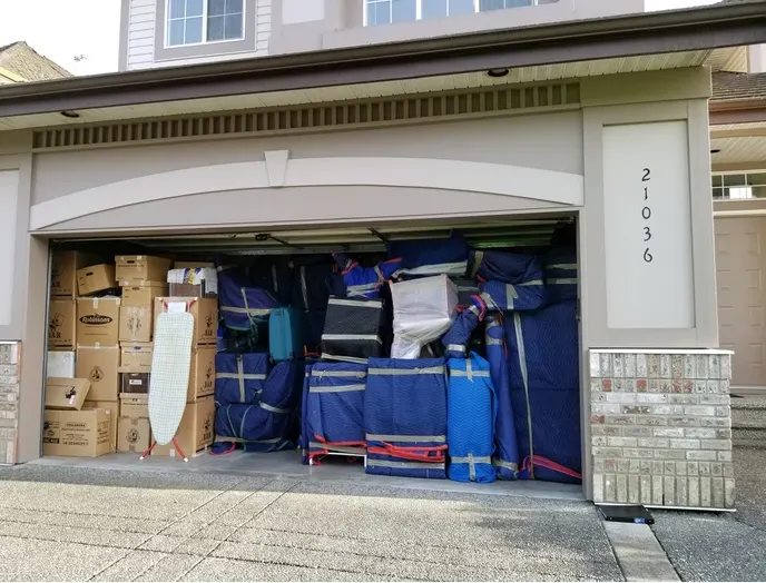 Garage filled with blanket-wrapped furniture and boxes ready for a move